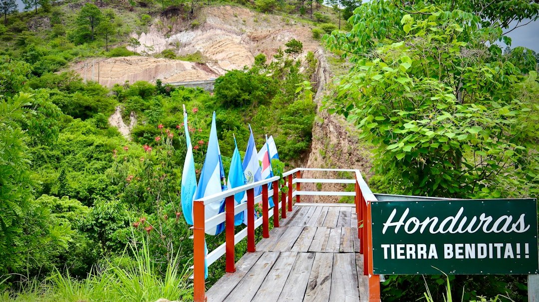 Photo by OSMAN ESPINOZA FRANCO Honduras sign and flags on a scenic wooden walkway.